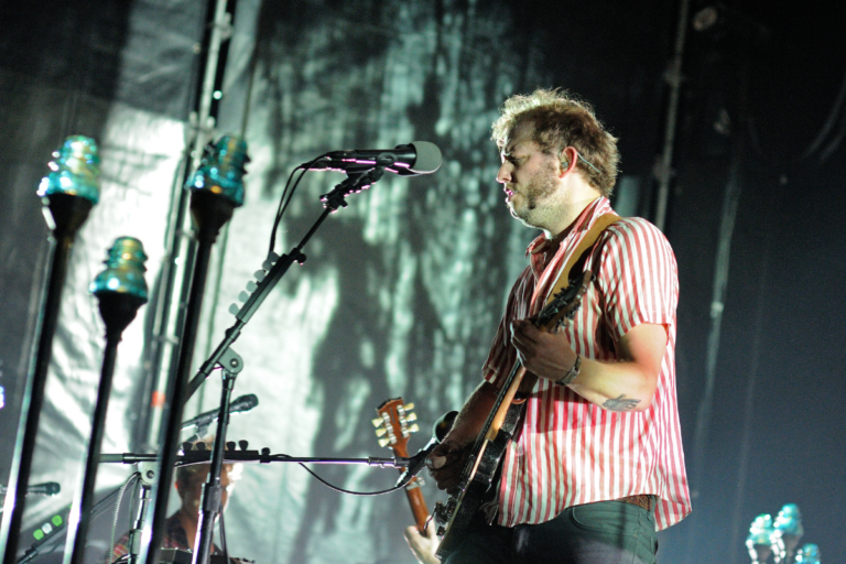 Bon Iver performing live on stage.