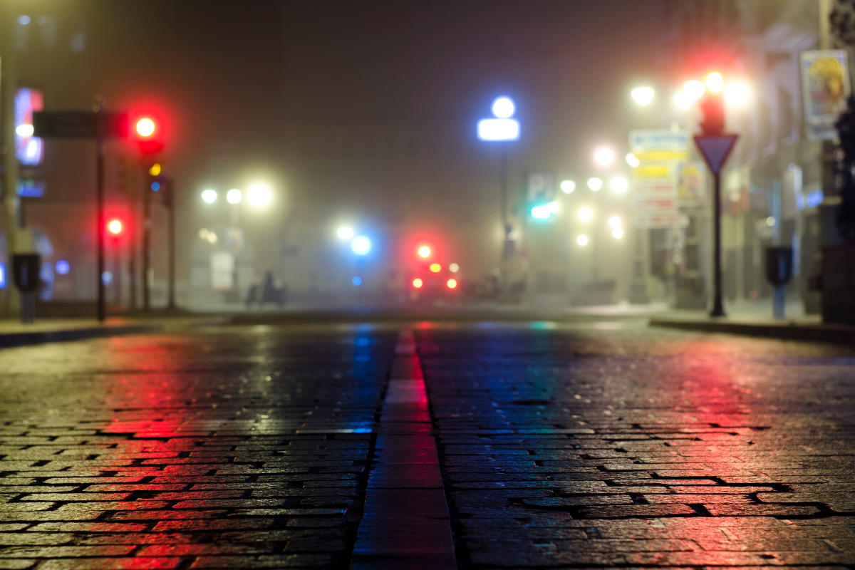 A dark street dimly lit by street lights.