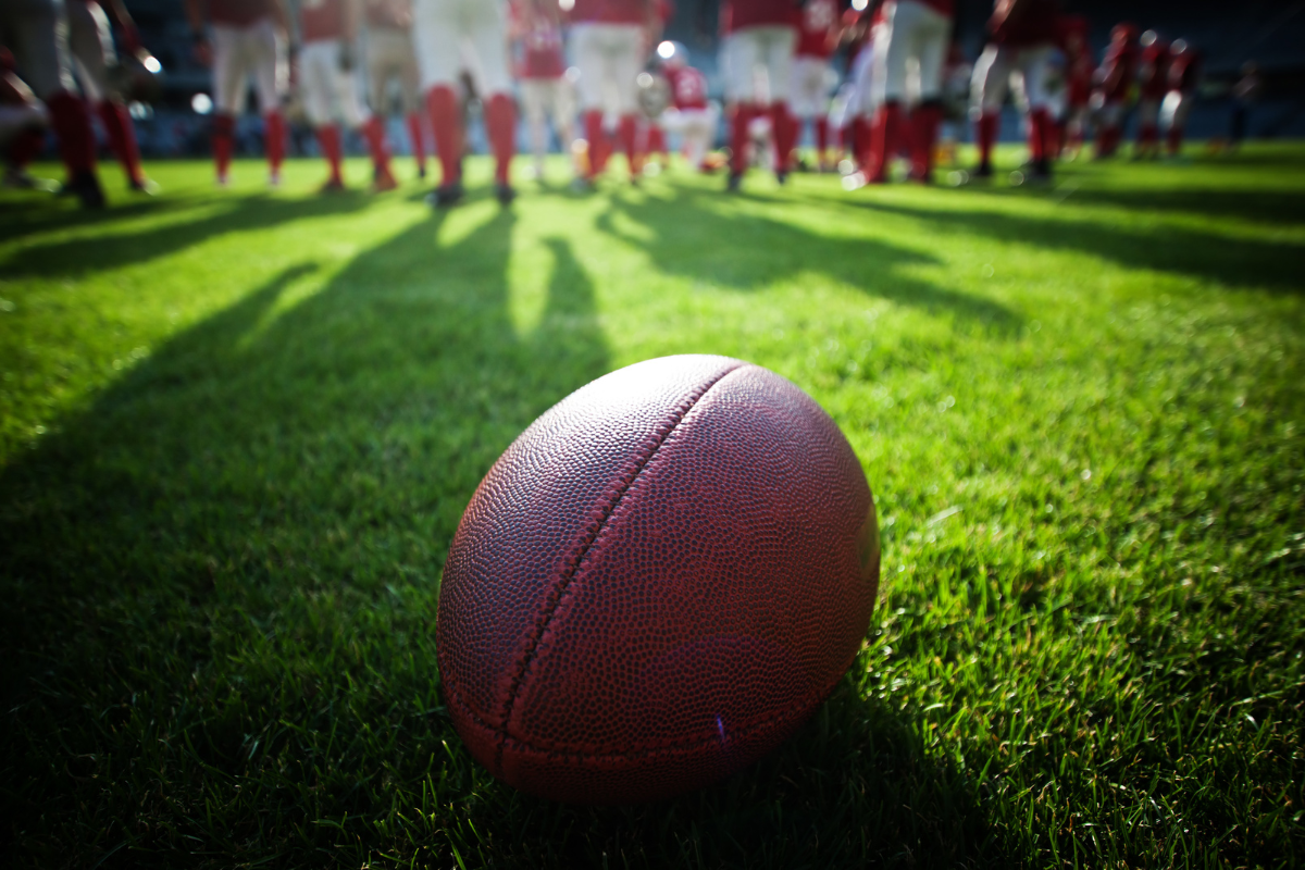 A football placed on an American football field.