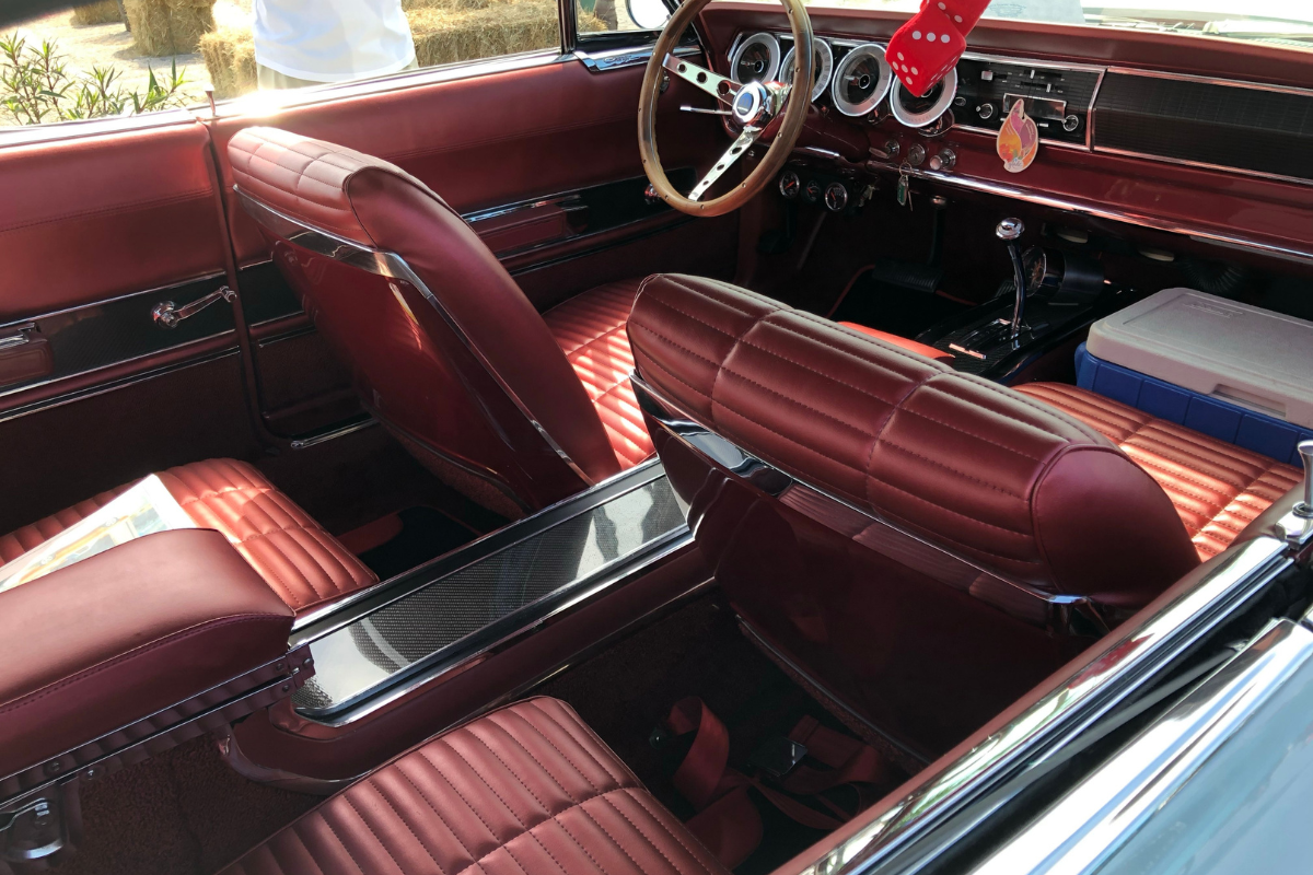 A vintage car with red leather seats.