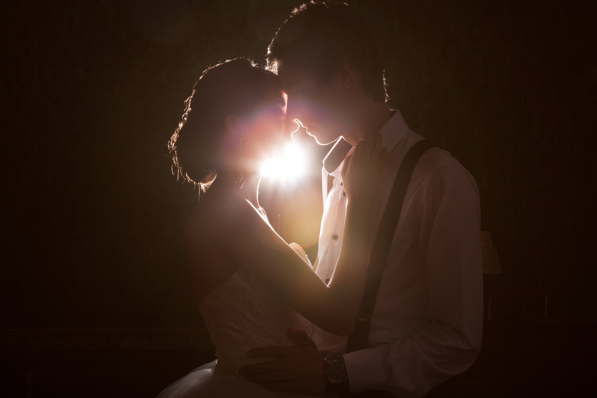 A couple embracing each other in a dimly lit room.