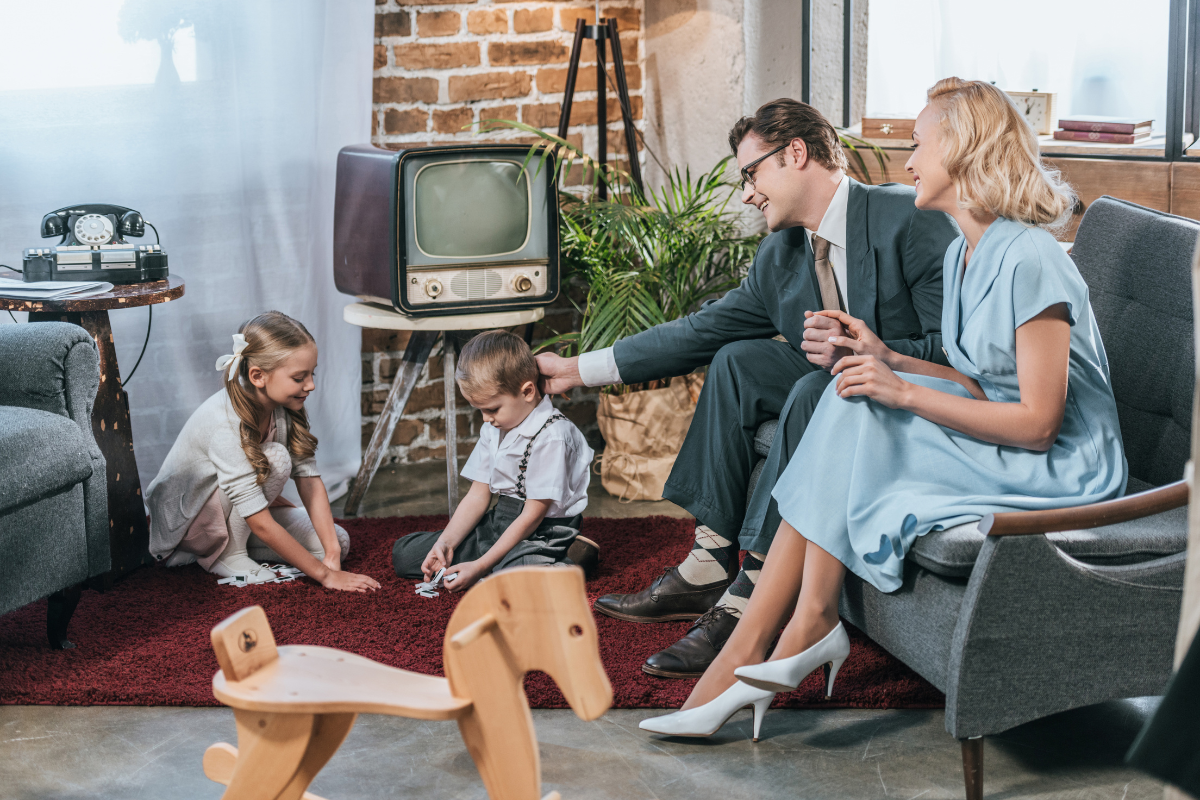 A family dressed in 1970s attire spending time in the living room.