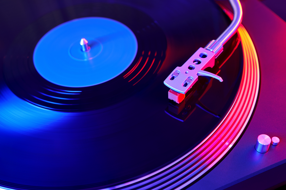 A record player with neon lights in the background.