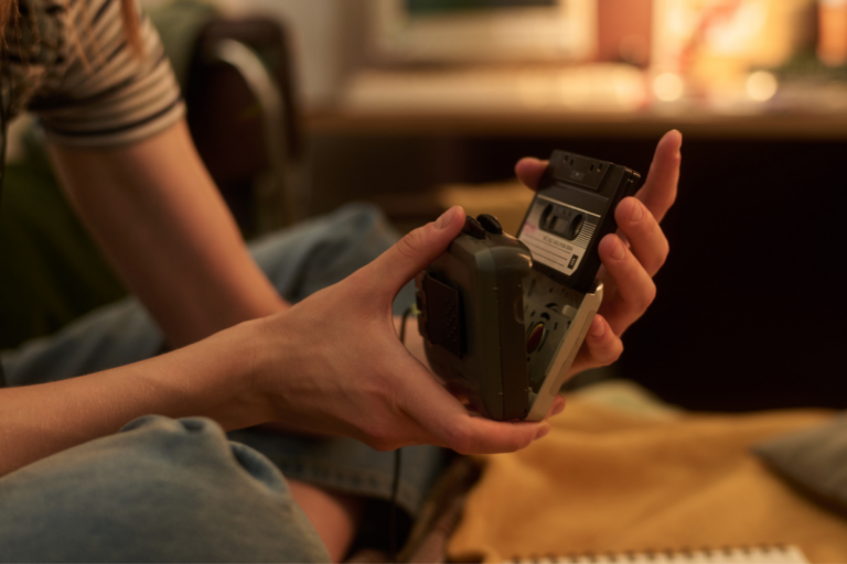 An image of a person holding a cassette recorder.